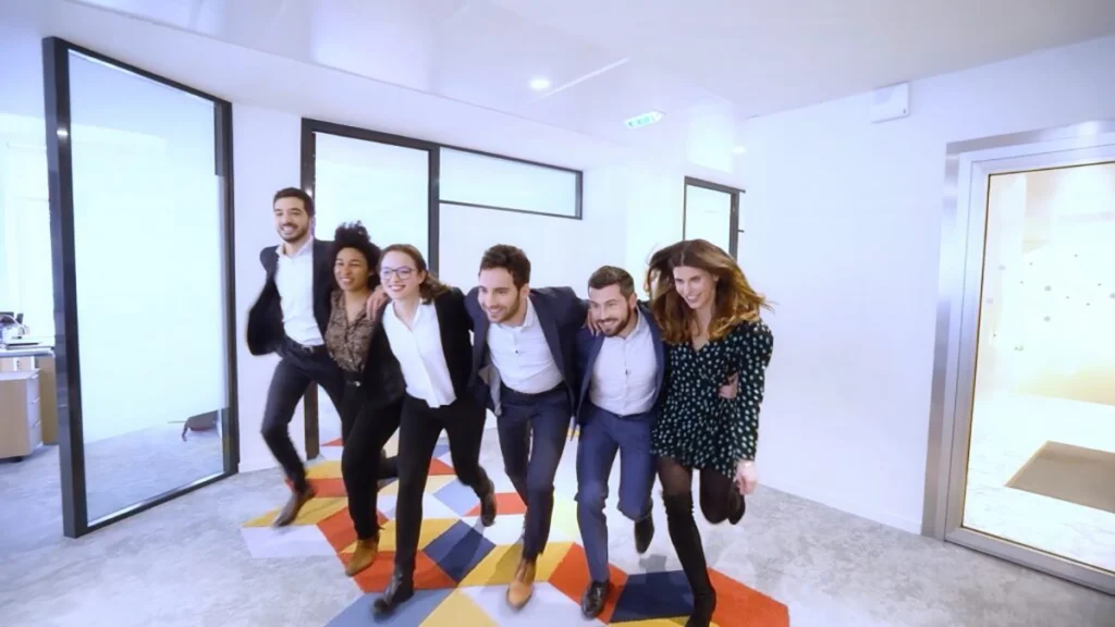 Groupe de jeunes collaborateurs marchant ensemble dans les locaux de leur entreprise, image extraite d’une vidéo marque employeur réalisée par l'agence de communication vidéo Scriptonic